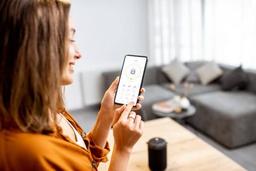 woman using phone to activate smart features in home