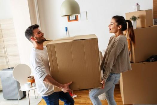 Couple lifting a large box.