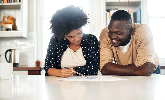 Couple sitting together reviewing a home offer.