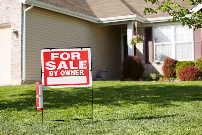 For Sale By Owner yard sign in front of a home.