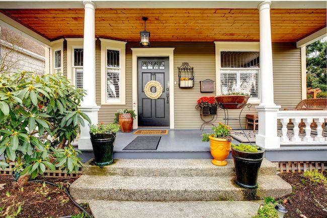 Cute front porch of a home with lots of planters.