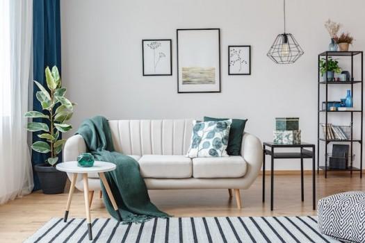 Living room staged with white couch and green accents.